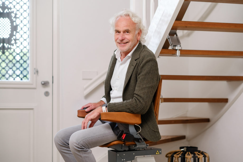 Homme âgé accoudé au monte-escalier